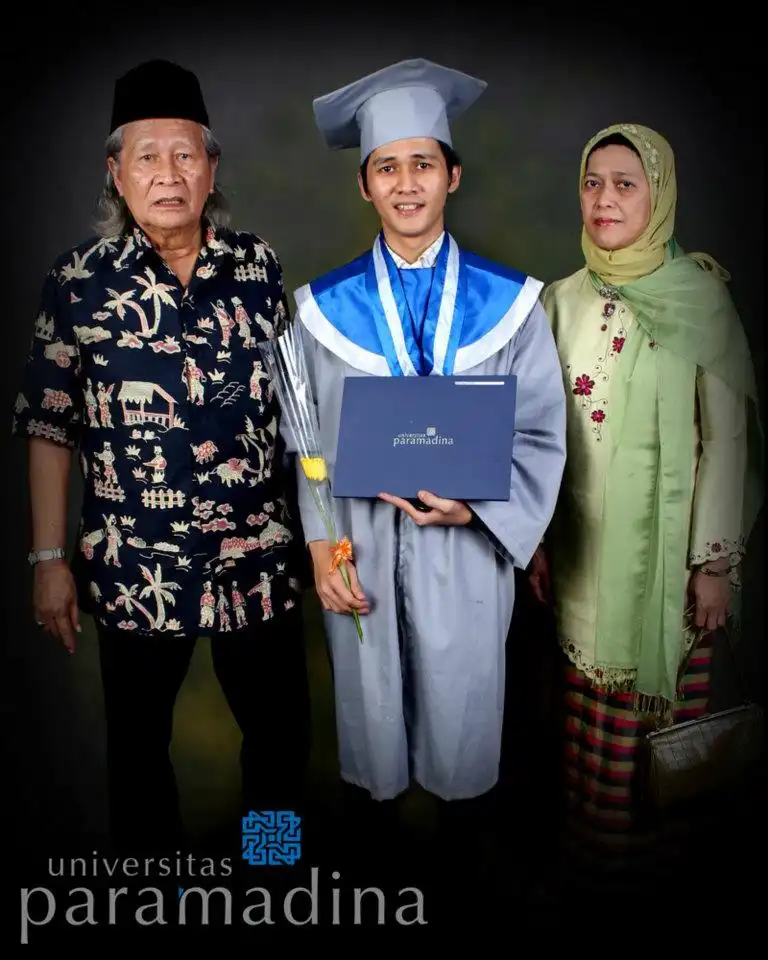 Rifat memakai toga dan memegang ijazah, berada di tengah-tengah Ayah dan Mama